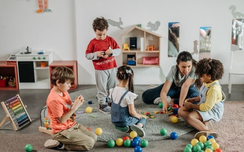 Early years practitioner supporting young children’s learning